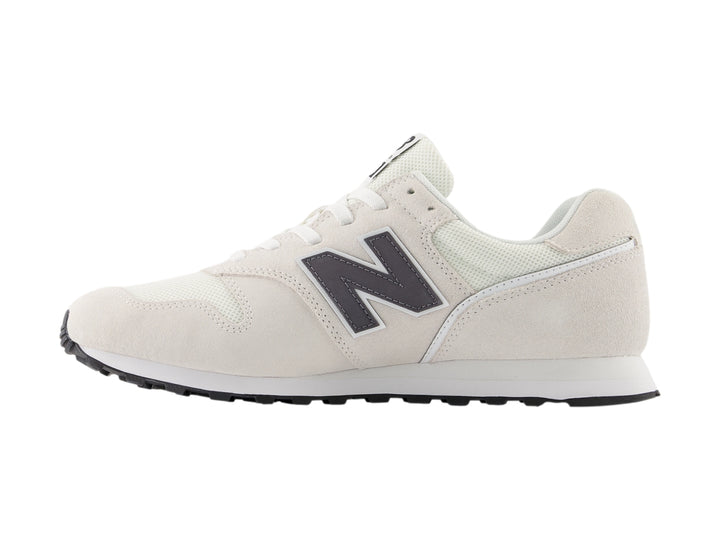 Tenis New Balance color gris con suela blanca y detalles en malla y gamuza.