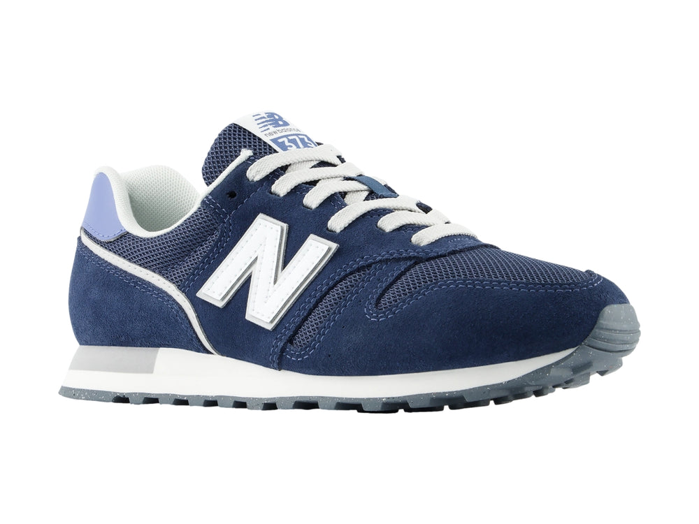 Tenis New Balance modelo 373 en color azul marino con detalles en blanco y lila, vista lateral.
