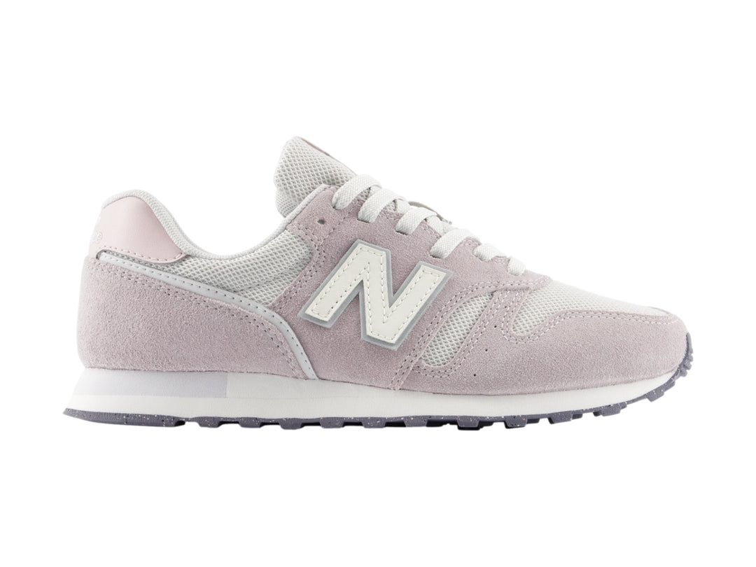 Tenis New Balance color gris claro con detalles en blanco y suela blanca.