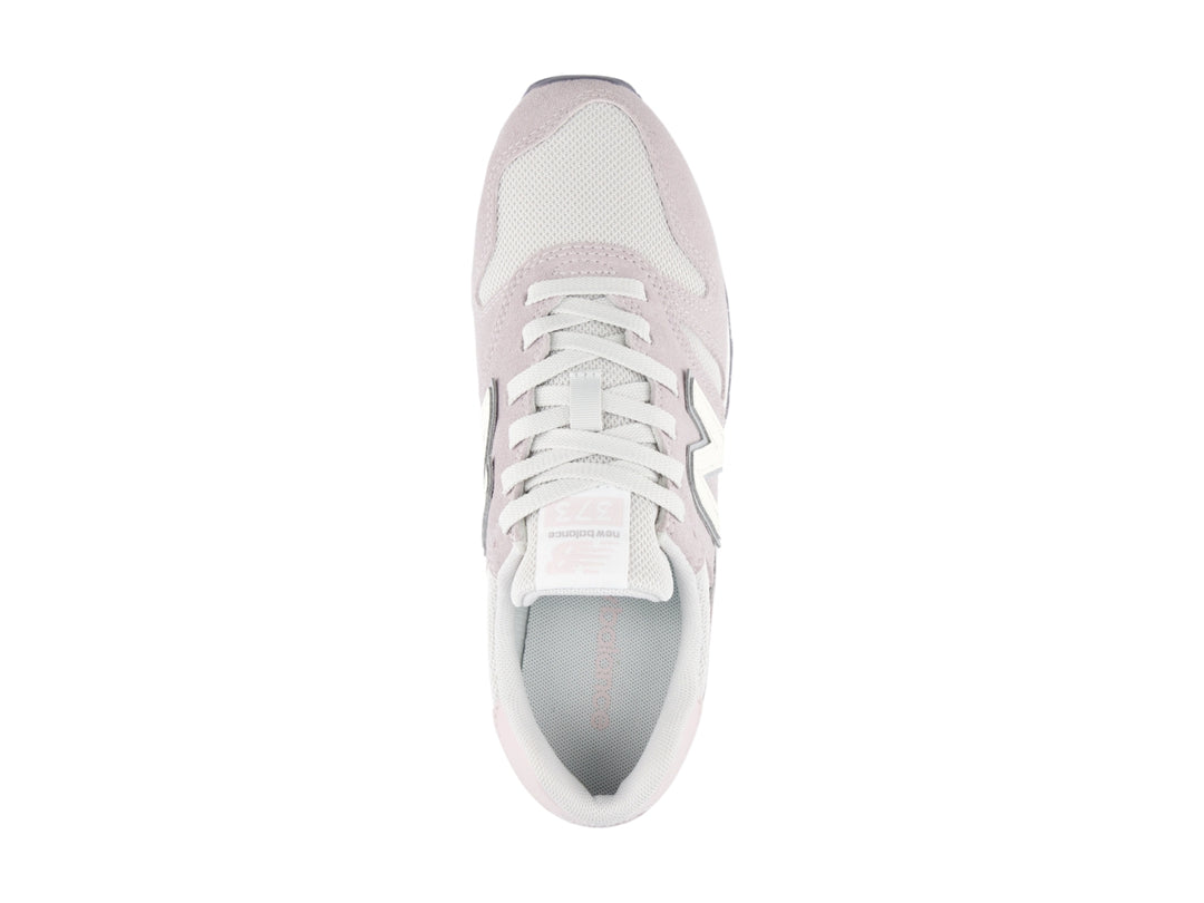 Tenis New Balance color gris claro con detalles en blanco y suela blanca.