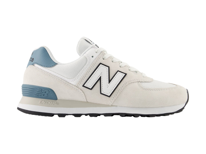 Tenis New Balance 574 color gris claro con detalles en azul y suela blanca para hombre.