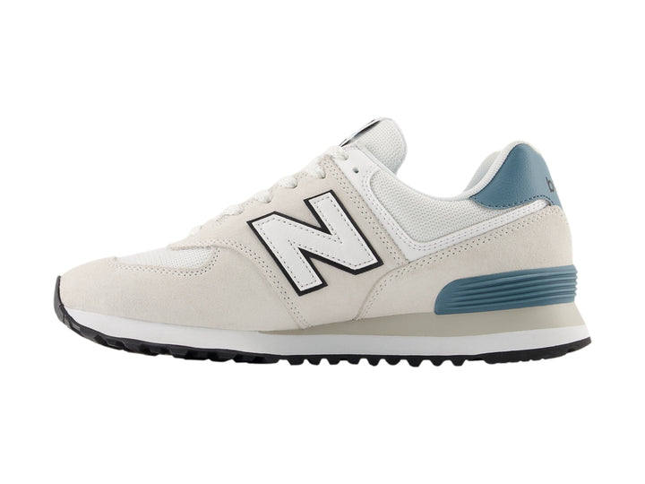 Tenis New Balance 574 color gris claro con detalles en azul y suela blanca para hombre.
