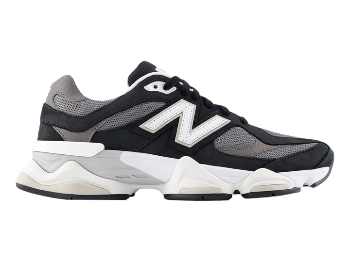 Tenis New Balance 9060 para mujer en color negro y blanco con suela gruesa y detalles en malla gris.