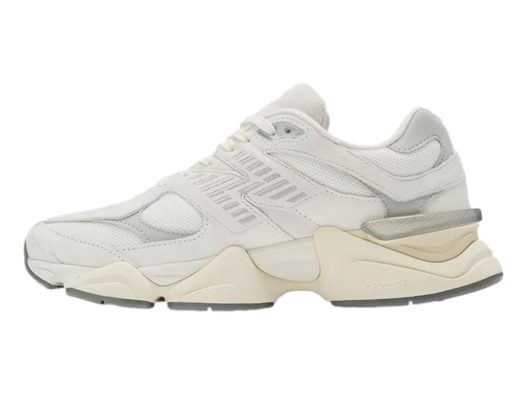 Tenis New Balance 9060 color blanco para mujer con suela gruesa y detalles en gris.