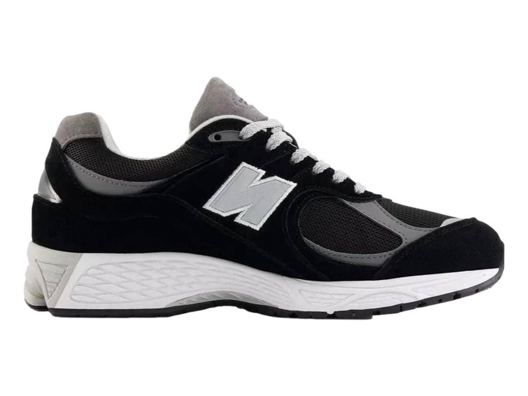 Tenis New Balance 2002RX color negro con suela blanca y detalles en gris para hombre.