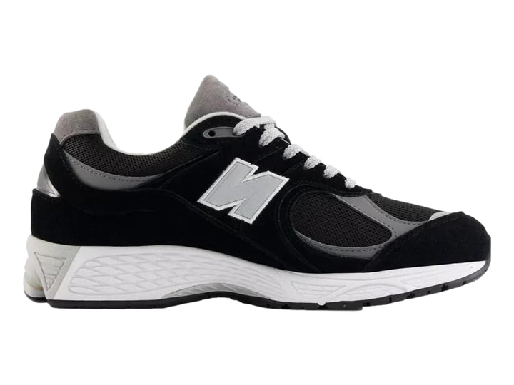 Tenis New Balance 2002RX color negro con suela blanca y detalles en gris para hombre.