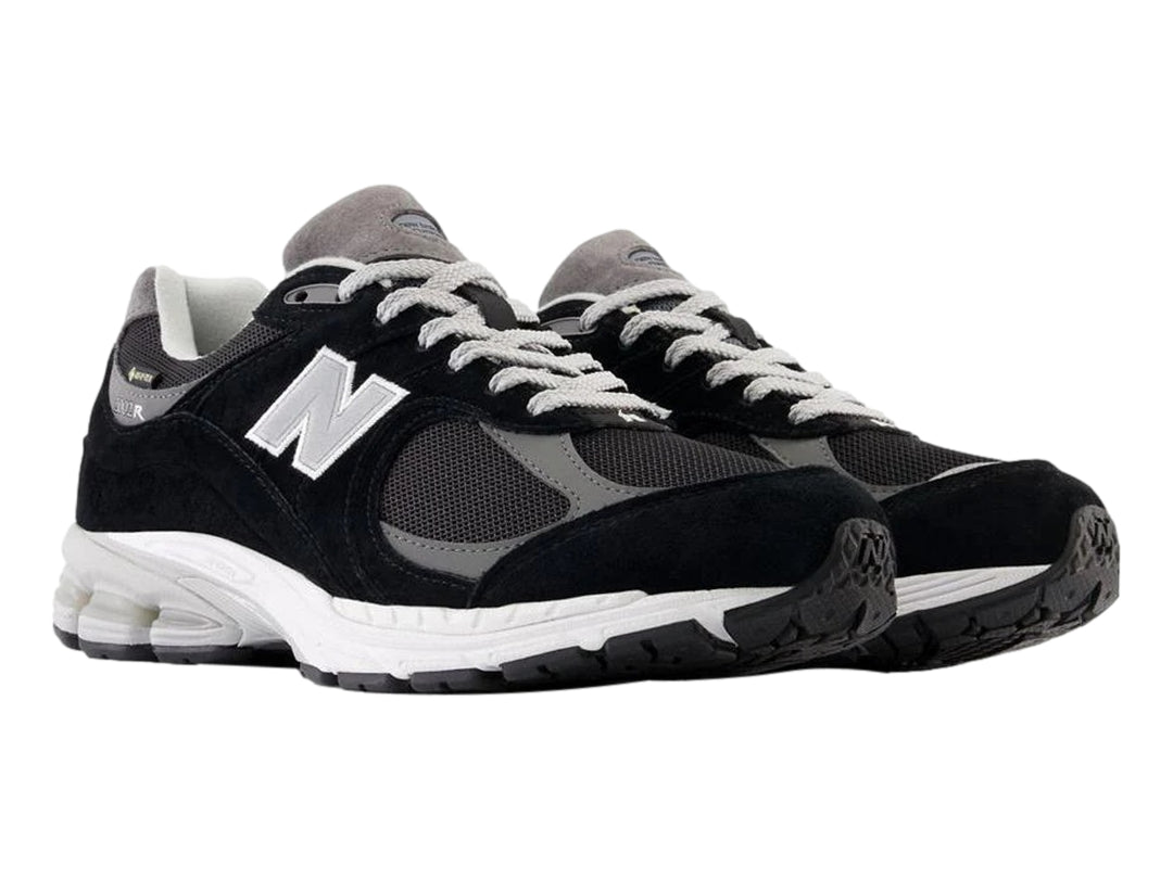 Tenis New Balance 2002RX color negro con suela blanca y detalles en gris para hombre.