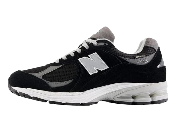 Tenis New Balance 2002RX color negro con suela blanca y detalles en gris para hombre.