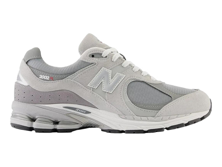 Tenis New Balance 2002RX color gris para mujer con detalles en malla y suela amortiguada.