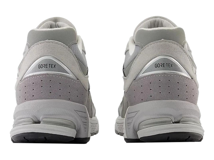 Tenis New Balance 2002RX color gris para mujer con detalles en malla y suela amortiguada.