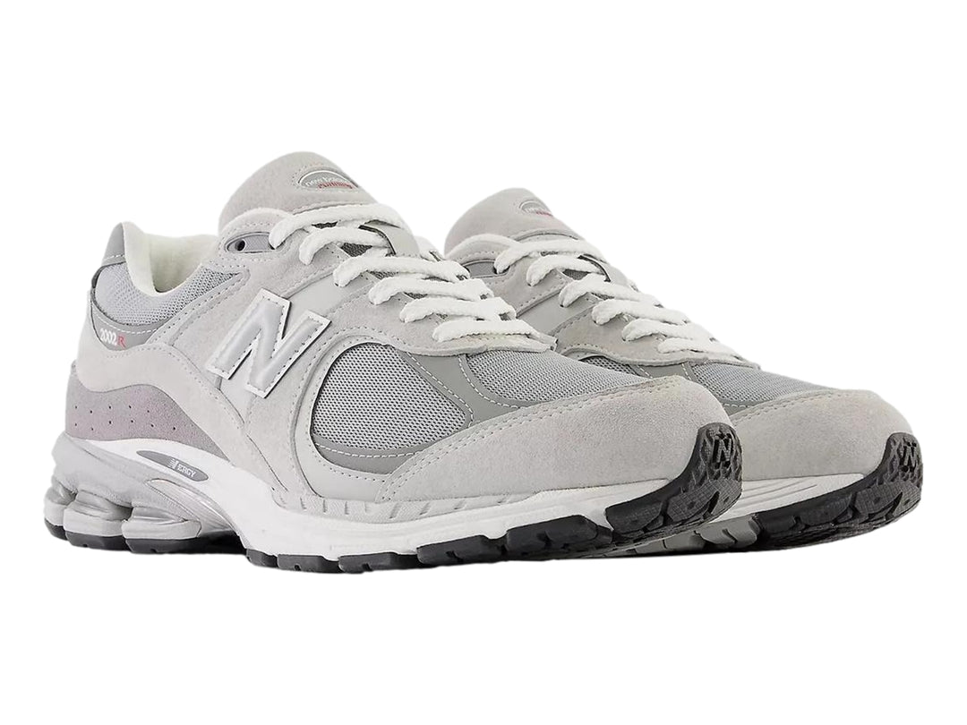Tenis New Balance 2002R color gris para hombre, vista lateral sobre fondo blanco.