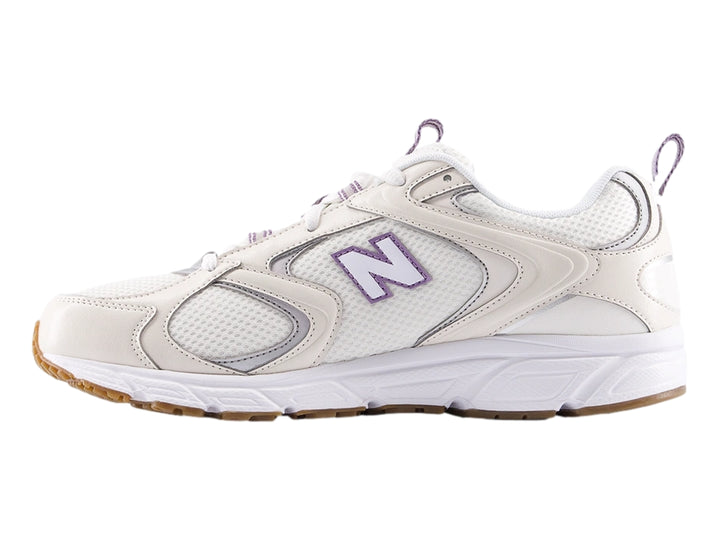 Tenis New Balance modelo 408 en color beige y blanco con detalles en malla y suela robusta.