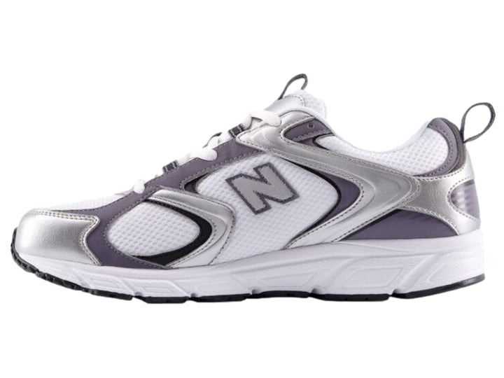 Tenis New Balance modelo 408 color blanco con detalles en plateado y morado.