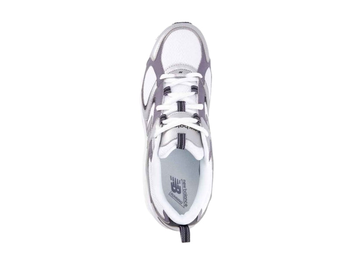 Tenis deportivos New Balance color blanco con detalles metálicos en plata y morado.