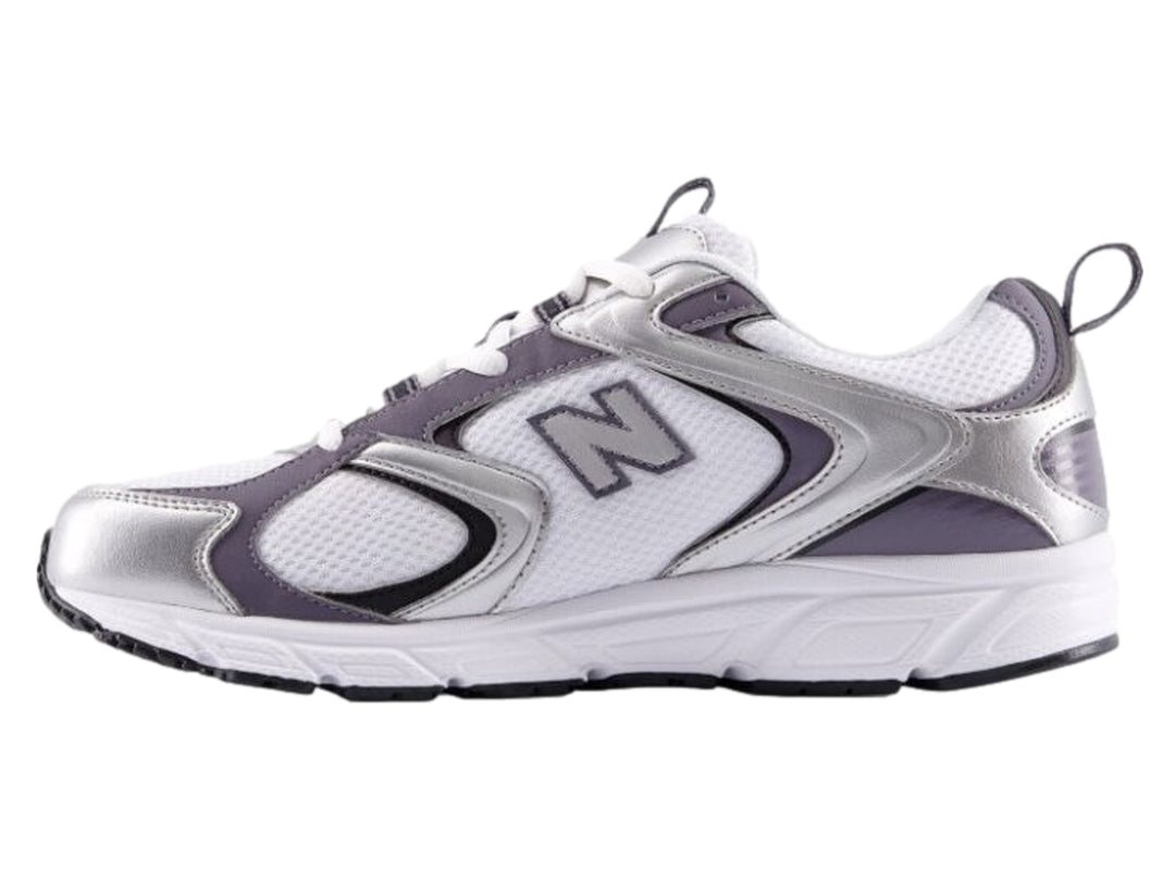 Tenis deportivos New Balance color blanco con detalles metálicos en plata y morado.