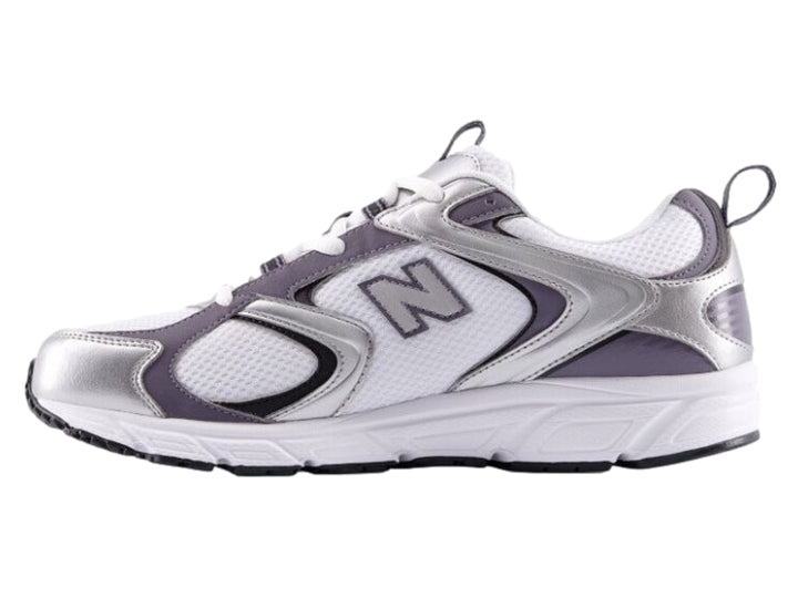 Tenis deportivos New Balance color blanco con detalles metálicos en plata y morado.