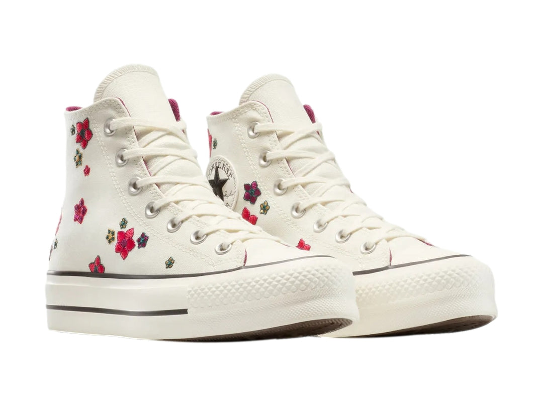 Tenis Converse botín color hueso con bordados de flores coloridas.
