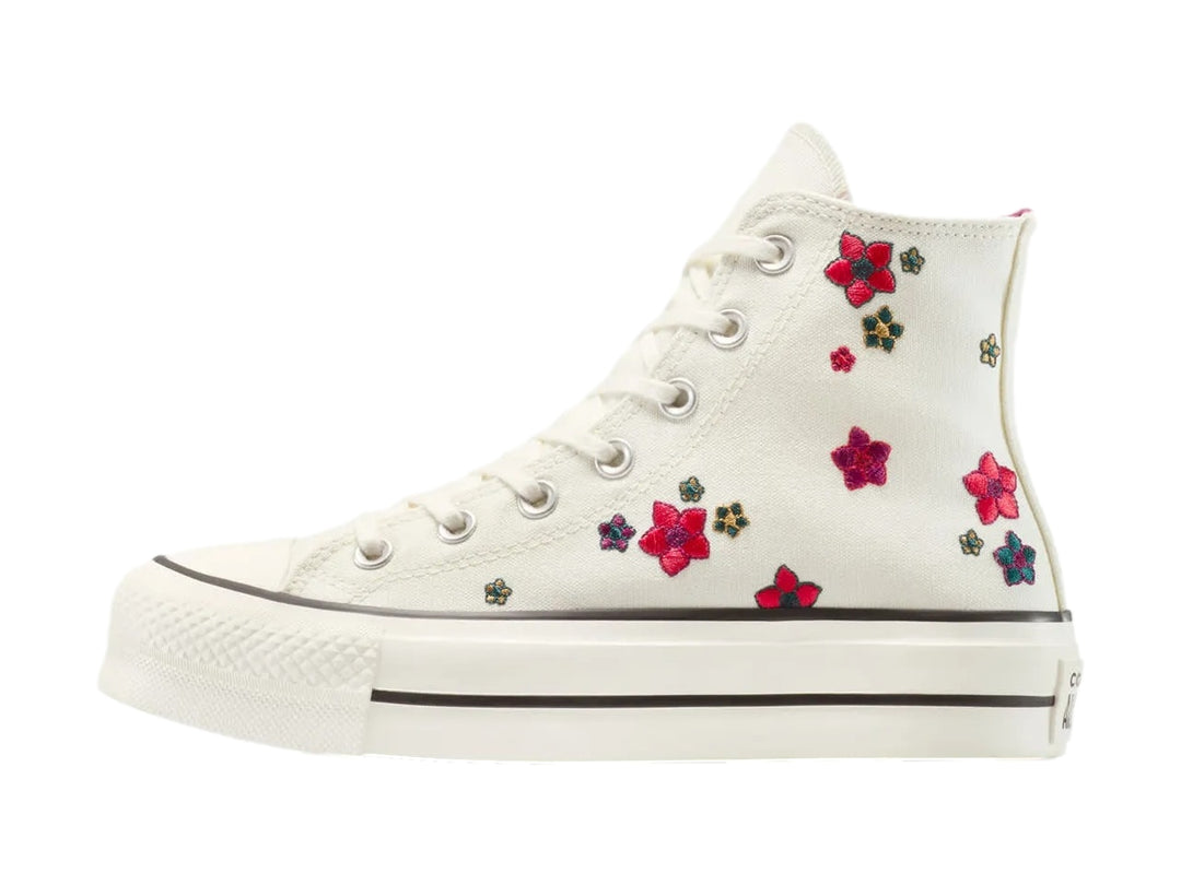 Tenis Converse botín color hueso con bordados de flores coloridas.