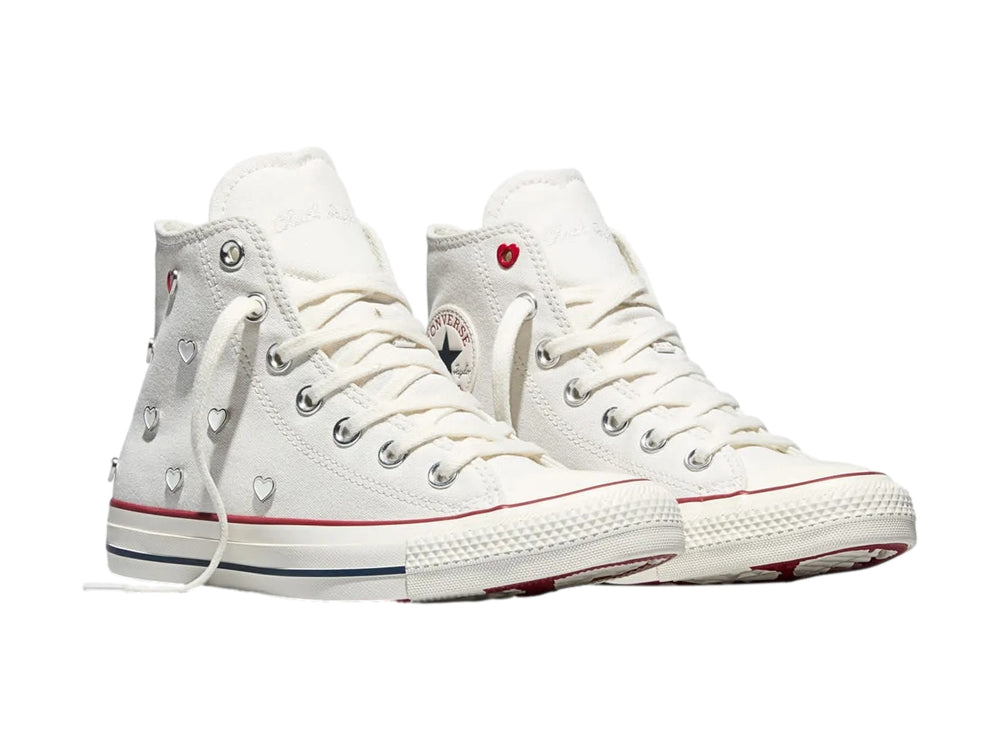 Tenis Converse Chuck Taylor All Star blancos de bota alta con detalles en rojo y azul.
