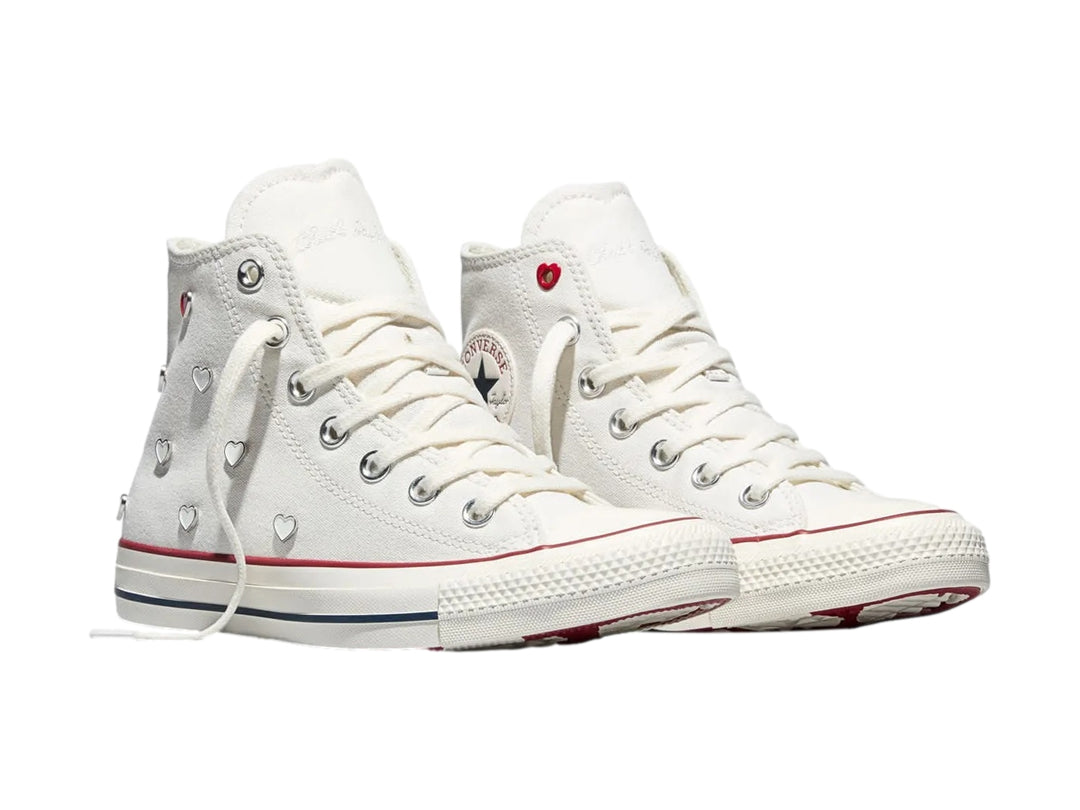 Tenis Converse Chuck Taylor All Star blancos de bota alta con detalles en rojo y azul.