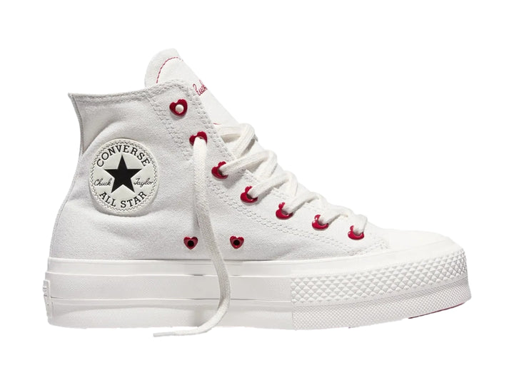 Tenis Converse blancos de bota con plataforma y ojillos rojos en forma de corazón.