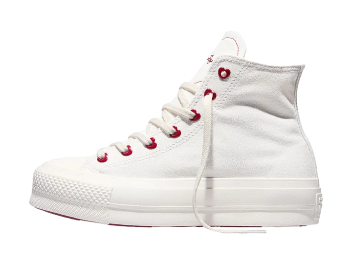 Tenis Converse blancos de bota con plataforma y ojillos rojos en forma de corazón.