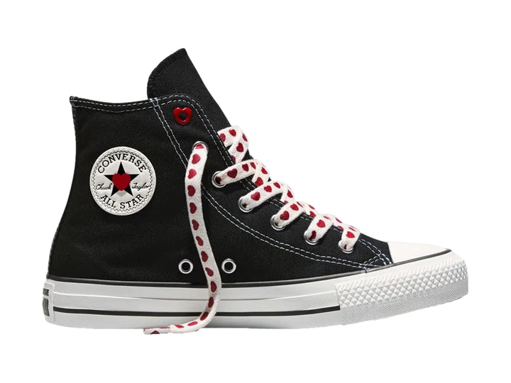 Tenis Converse negros de bota alta con suela blanca y agujetas blancas decoradas con corazones rojos.