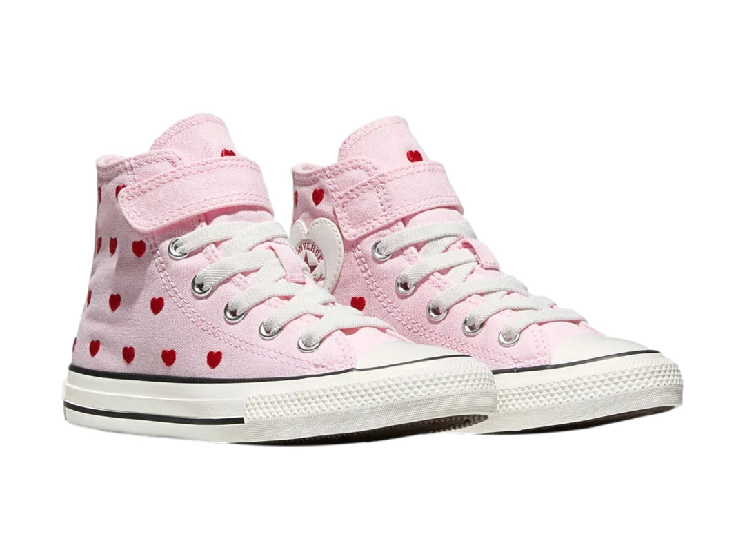 Tenis Converse rosas de bota con estampado de corazones rojos y un parche de corazón blanco.
