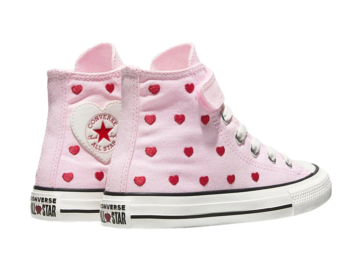 Tenis Converse rosas de bota con estampado de corazones rojos y un parche de corazón blanco.