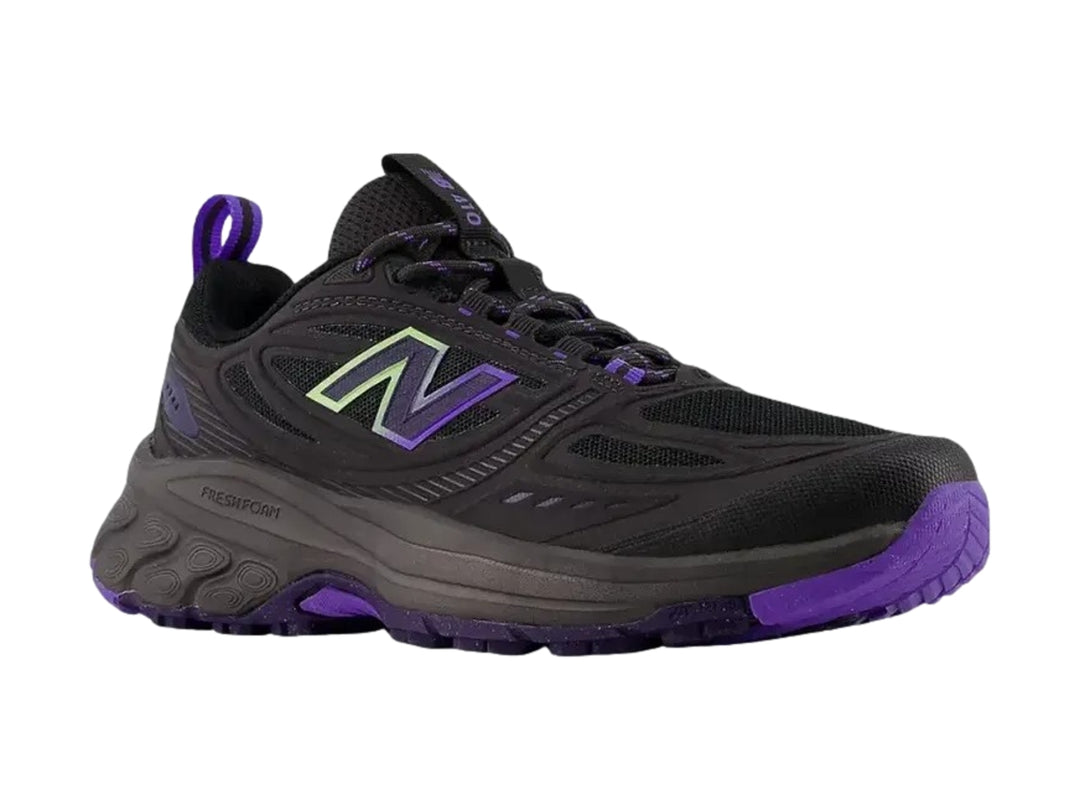 Tenis deportivos New Balance color negro con detalles en morado y suela rugosa.