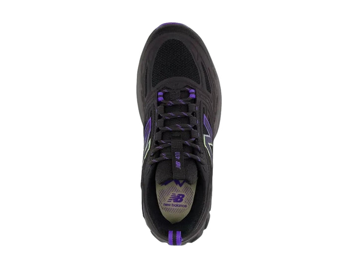 Tenis deportivos New Balance color negro con detalles en morado y suela rugosa.