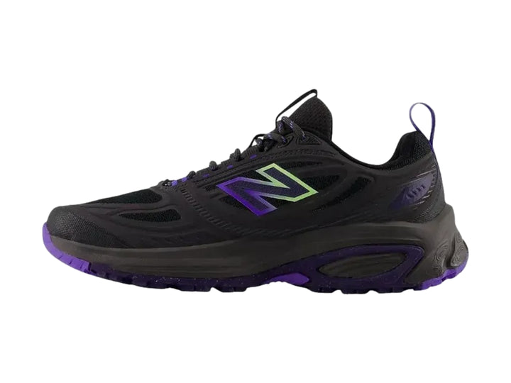 Tenis deportivos New Balance color negro con detalles en morado y suela rugosa.