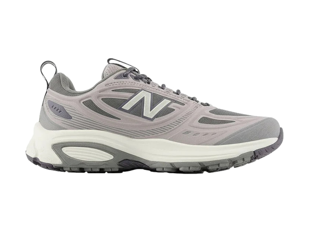 Tenis deportivos New Balance color gris con suela blanca y tejido de malla.