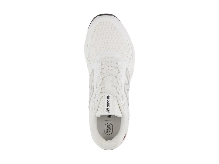Tenis deportivos New Balance color blanco con suela negra y tejido de malla.