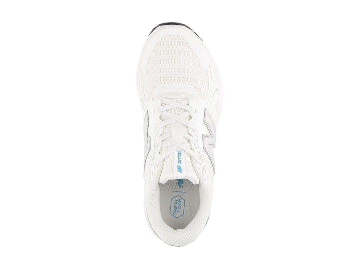 Tenis New Balance color blanco con detalles en gris y azul, diseño deportivo de malla transpirable.