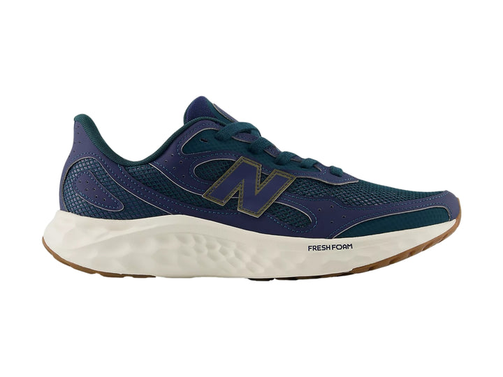 Tenis deportivos New Balance color azul con suela blanca y marrón.