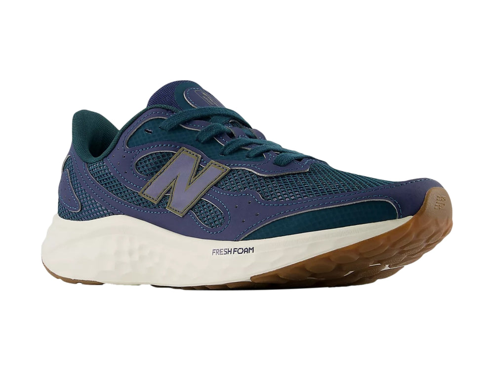Tenis deportivos New Balance color azul con suela blanca y marrón.