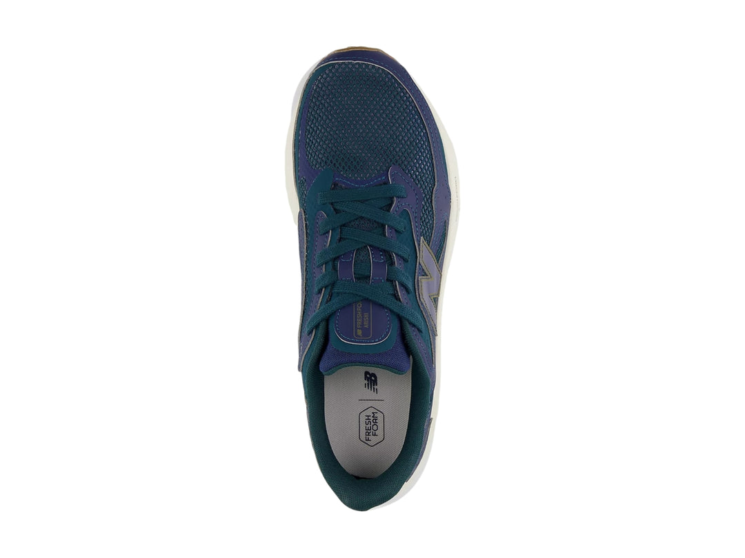 Tenis deportivos New Balance color azul con suela blanca y marrón.