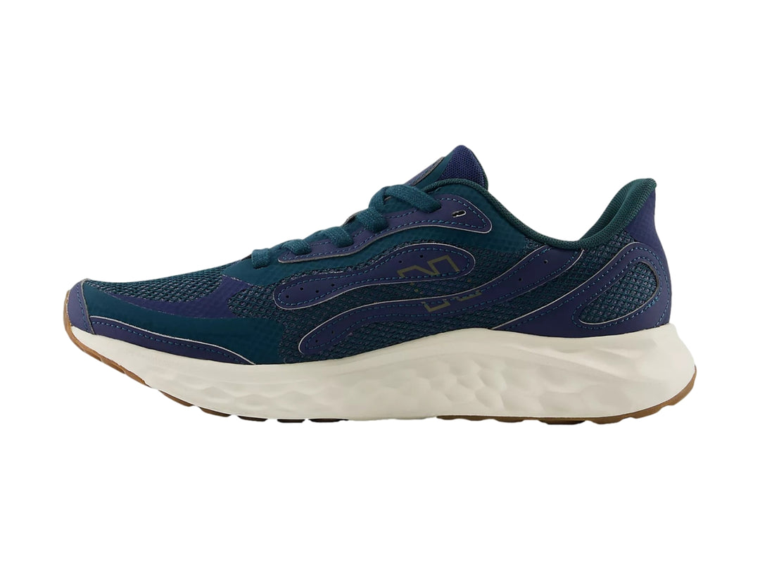 Tenis deportivos New Balance color azul con suela blanca y marrón.