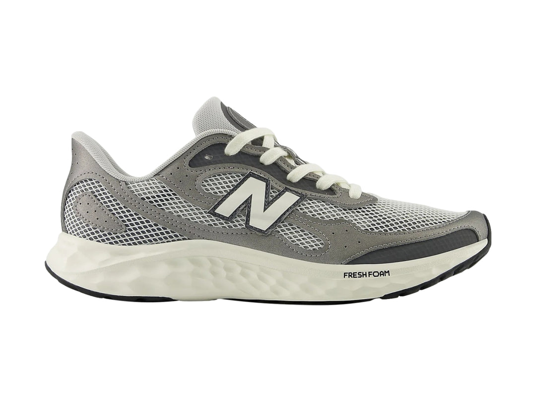 Tenis New Balance Arishi color gris con suela blanca y detalles en malla para hombre.