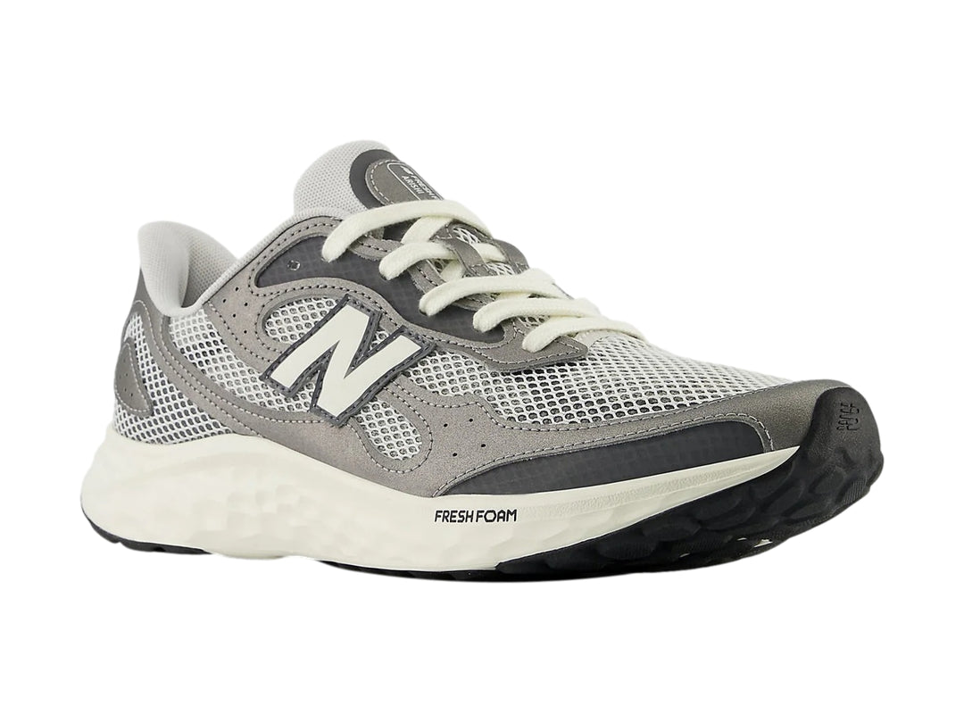 Tenis New Balance Arishi color gris con suela blanca y detalles en malla para hombre.