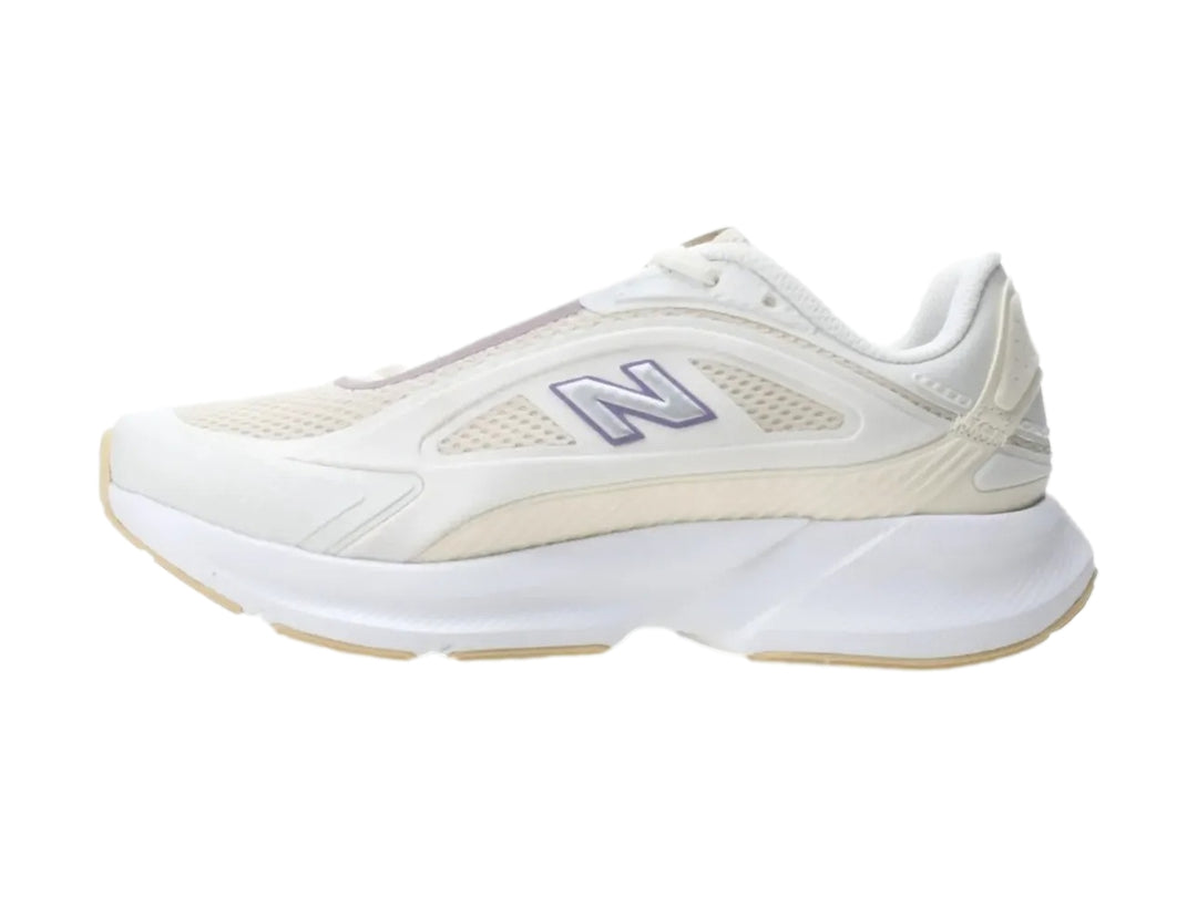 Tenis New Balance color blanco con detalles en morado y suela blanca robusta.