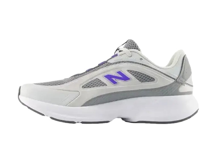 Tenis New Balance modelo W Cat en color gris y blanco con logotipo azul lateral y suela blanca robusta.