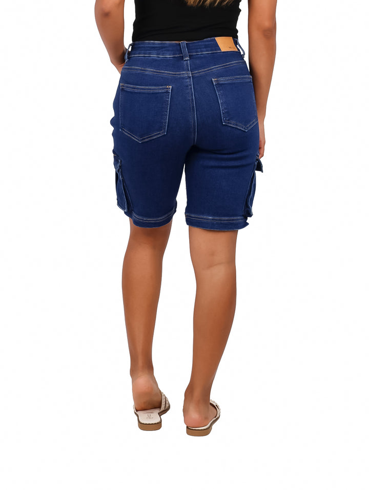 Mujer vistiendo shorts cargo de color azul oscuro con bolsillos laterales.