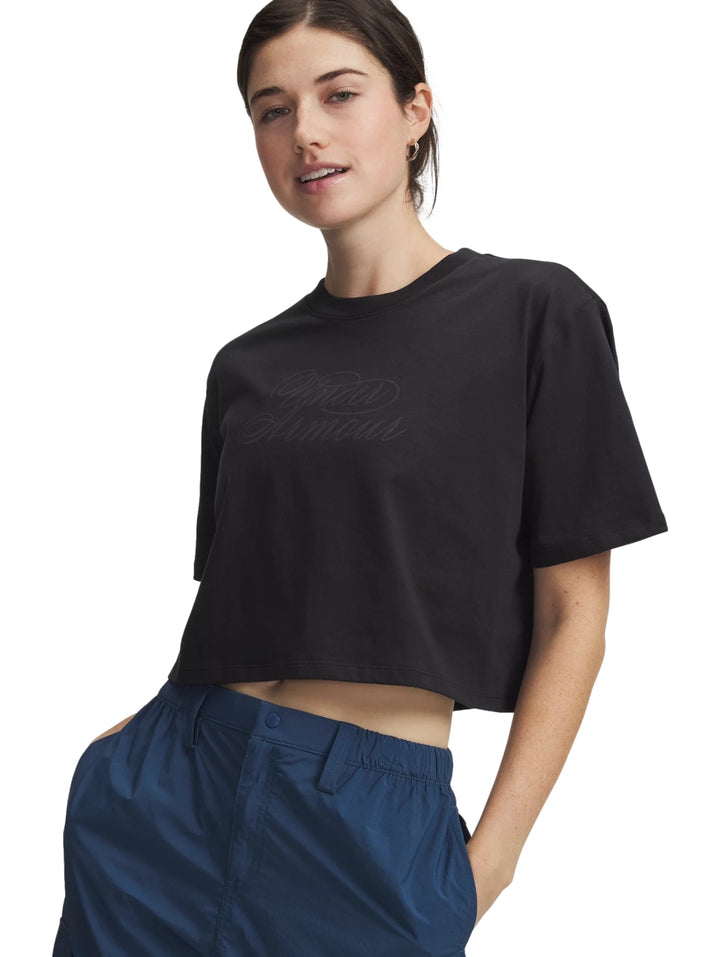 Mujer vistiendo una camiseta crop top negra de manga corta de la marca Under Armour.