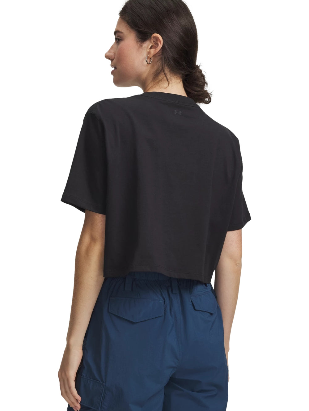 Mujer vistiendo una camiseta crop top negra de manga corta de la marca Under Armour.