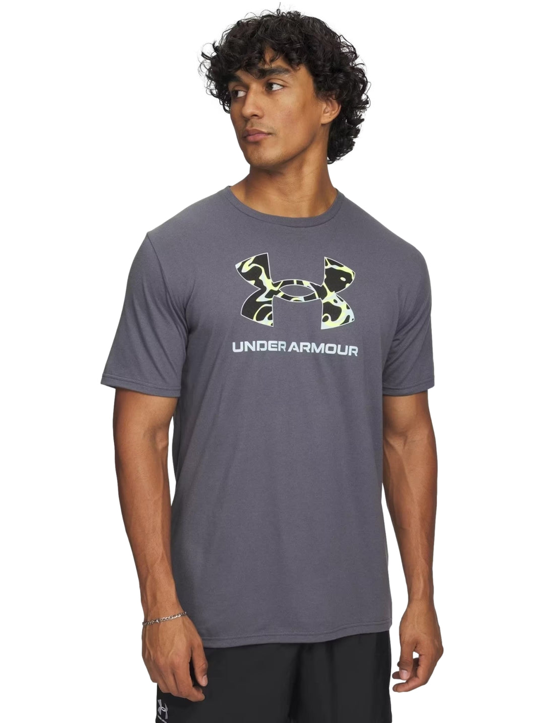 Hombre vistiendo camiseta deportiva gris de manga corta con logotipo de Under Armour en el pecho.