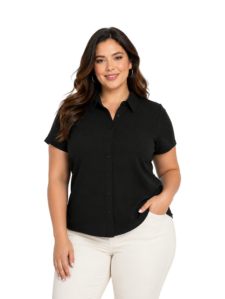 Mujer vistiendo blusa negra de manga corta con botones y pantalones blancos.