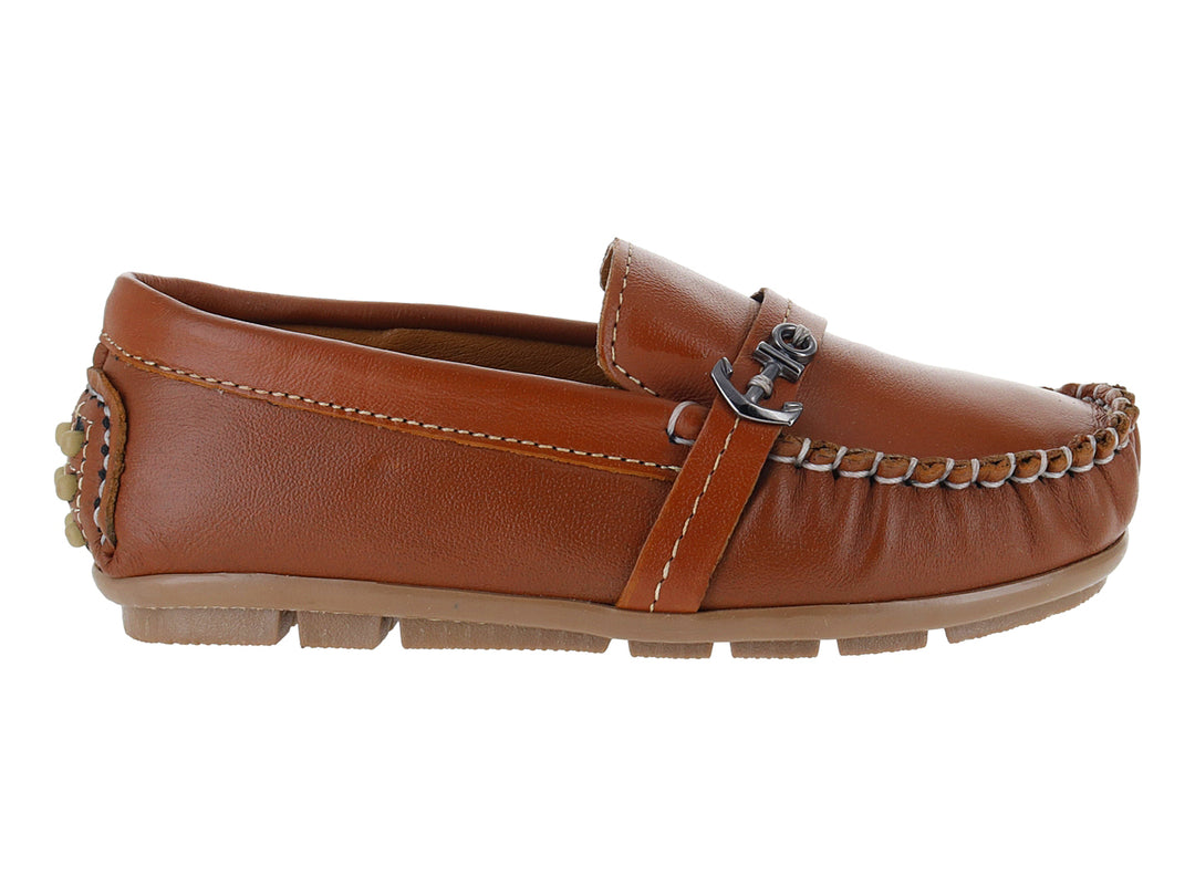 Zapato tipo mocasín para niño en piel color camel con costuras blancas y adorno metálico en el empeine.