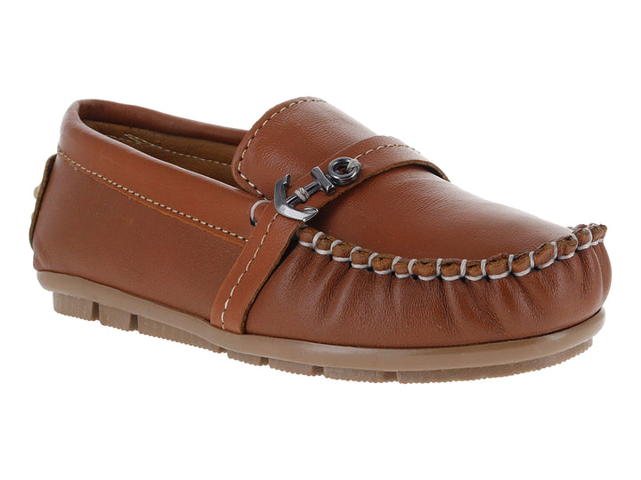 Zapato tipo mocasín para niño en piel color camel con costuras blancas y adorno metálico en el empeine.